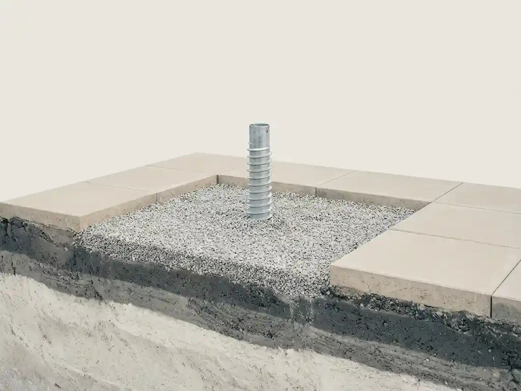 stalen-schroeffundering-paal-grondwerk-installatie.jpg Stalen schroeffundatie paal op geëgaliseerde grindlaag met betonnen tegels en gecompacteerde grondlagen in dwarsdoorsnede