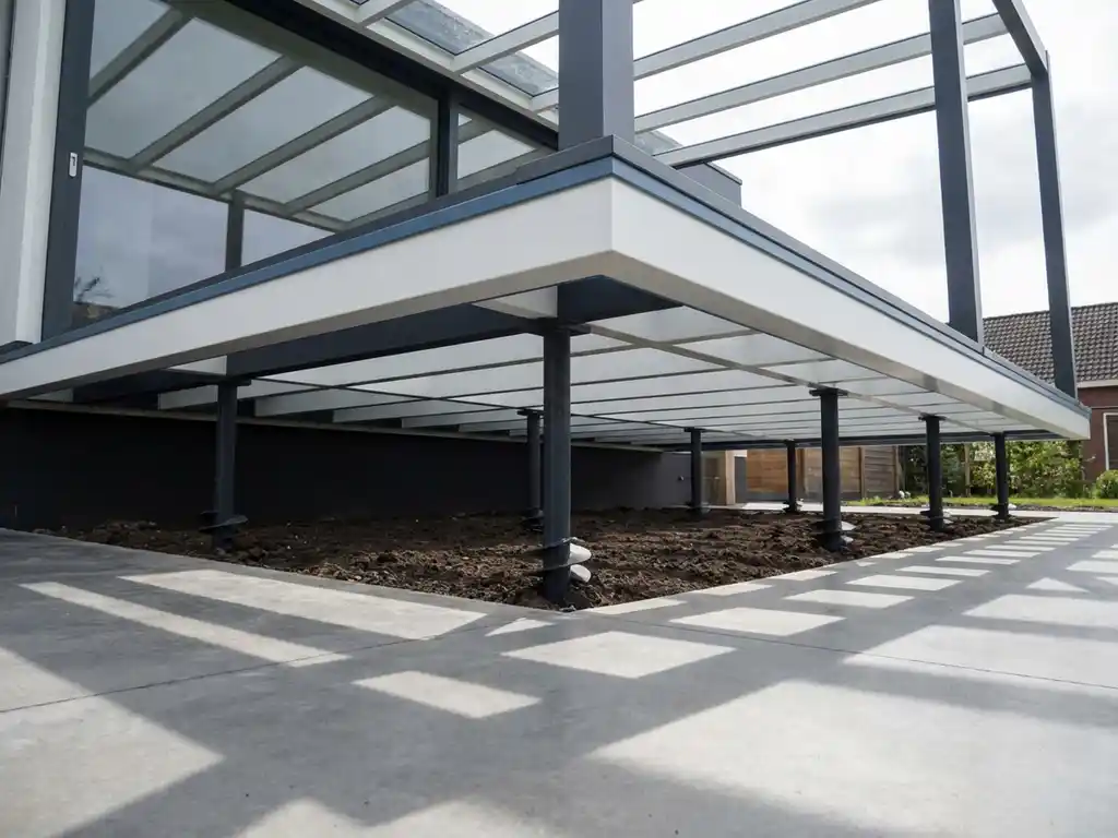 Moderne terrasoverkapping op stalen schroeffunderingen boven betonnen terras met geometrische schaduwpatronen