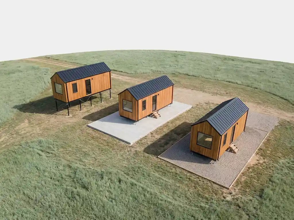 Tiny house met natuurlijke houten gevelbekleding op verschillende funderingstypes: stalen schroeffunderingen, betonplaten en grindbed in glooiend landschap